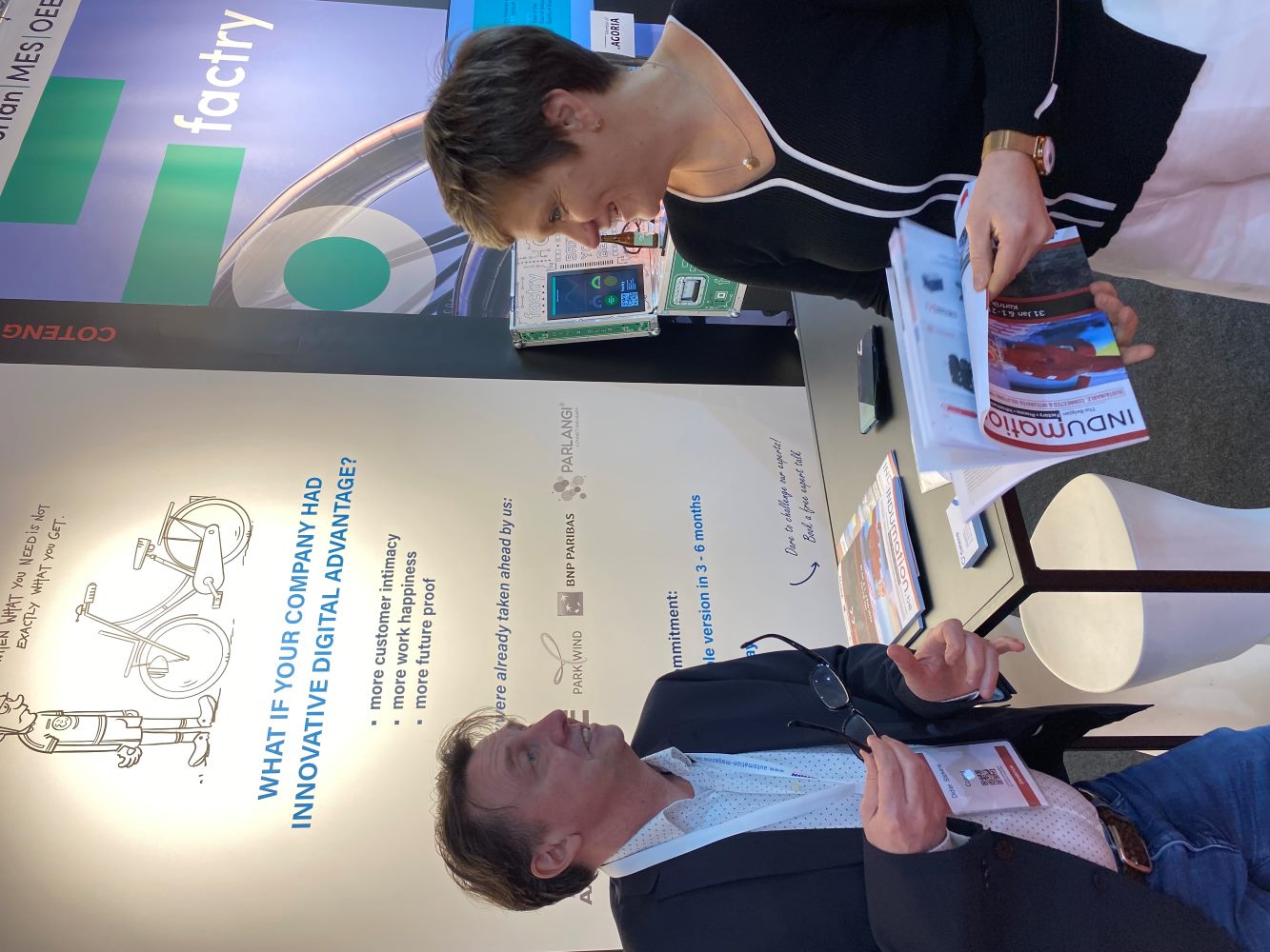 Coteng booth at Indumation 2024 with Didier Stickens and Dominique Weyers talking at the desk.